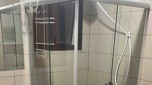 A modern bathroom with a glass-enclosed shower, a granite countertop, and a toilet.