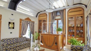 Un amplio salón con techo alto, una recepción de madera y una gran estantería.
