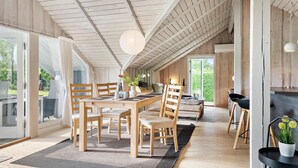 A spacious dining area with a wooden table and chairs, a hanging light fixture, and a view of greenery outside. - Awesome home in Hejls with WiFi (Hejls)