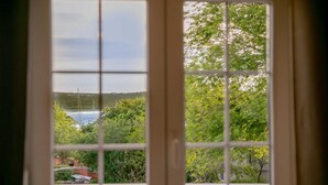 A window with a view of a body of water, trees, and a distant shoreline. - 4 bedroom beautiful home in Klimno (Klimno)