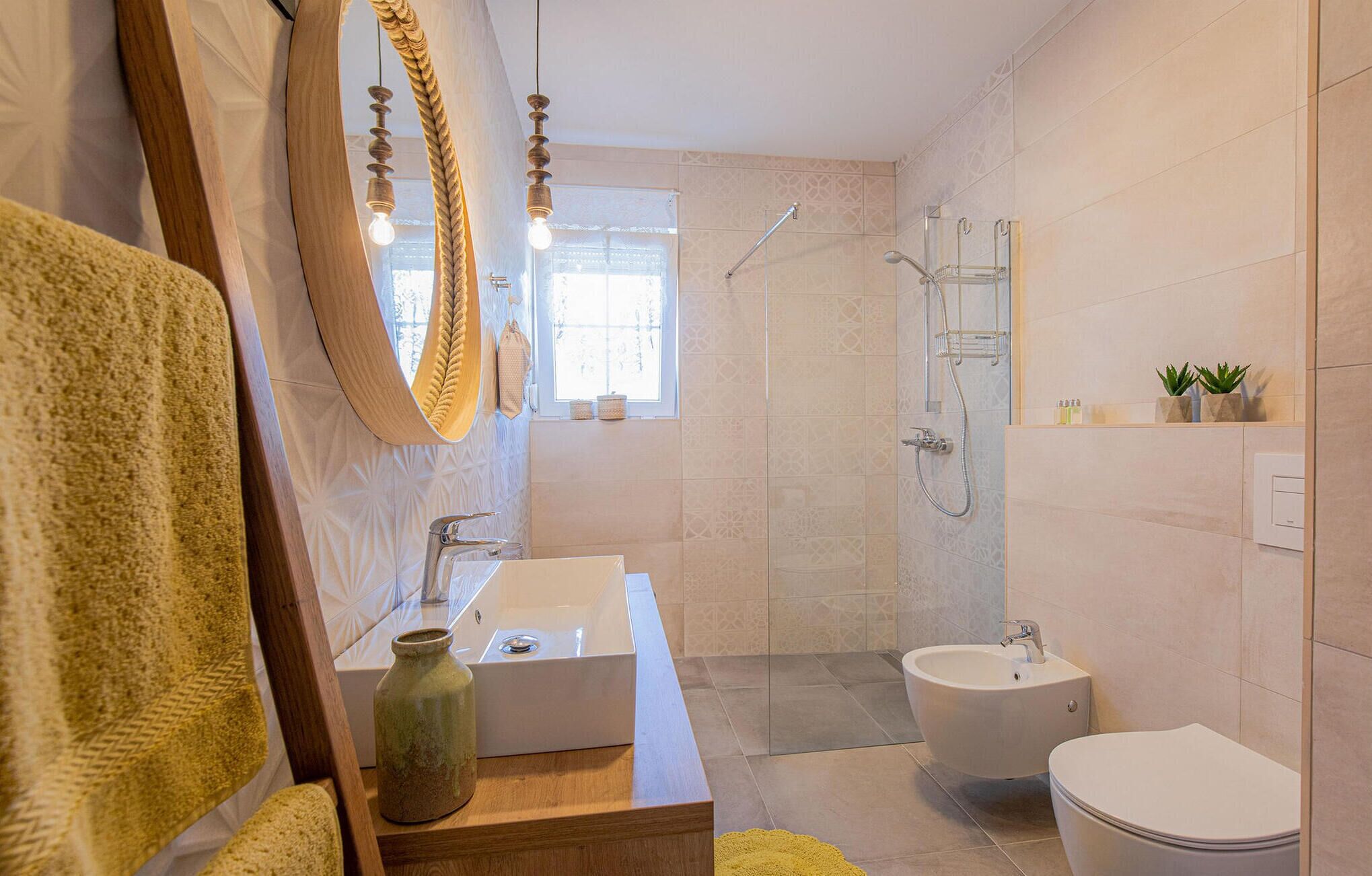 A modern bathroom with a wooden vanity, a large mirror, a shower, and a toilet.