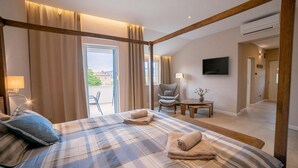 A hotel room with a large bed, a chair, a small table, and a TV. - 4 bedroom beautiful home in Klimno (Klimno)