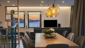 Un comedor moderno con una mesa de madera, sillas tapizadas de color gris y un jarrón decorativo con flores.