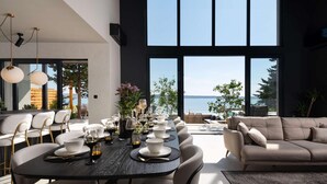 A modern dining area with a large table set for six, surrounded by chairs. A sofa is placed in the foreground. - Villa Beatrice (Soho) (Starigrad)