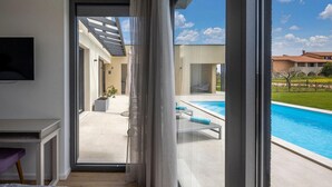 Ein modernes Interieur mit einer großen Schiebeglasdoor zum Außenbereich mit Schwimmbad.