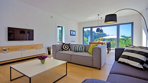 Un salon moderne avec un canapé, une table basse et un téléviseur fixé au mur.