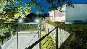 Une maison moderne dotée d’une piscine, d’un patio couvert et d’une pelouse bien entretenue.
