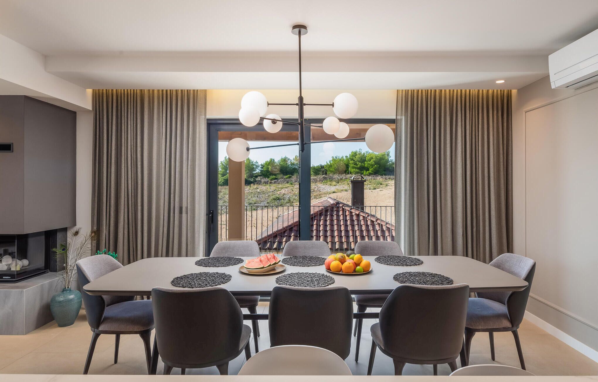 Un comedor moderno con una mesa grande, sillas y vistas al exterior.