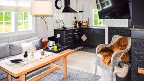 A modern living room with a sofa, a wooden coffee table, and a wicker chair. - 3 bedroom nice home in Gol (Gol)