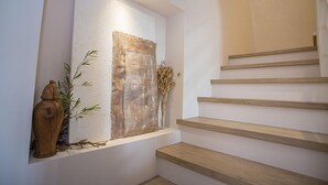 Una escala amb graons de fusta i una obra d'art penjada a la paret.