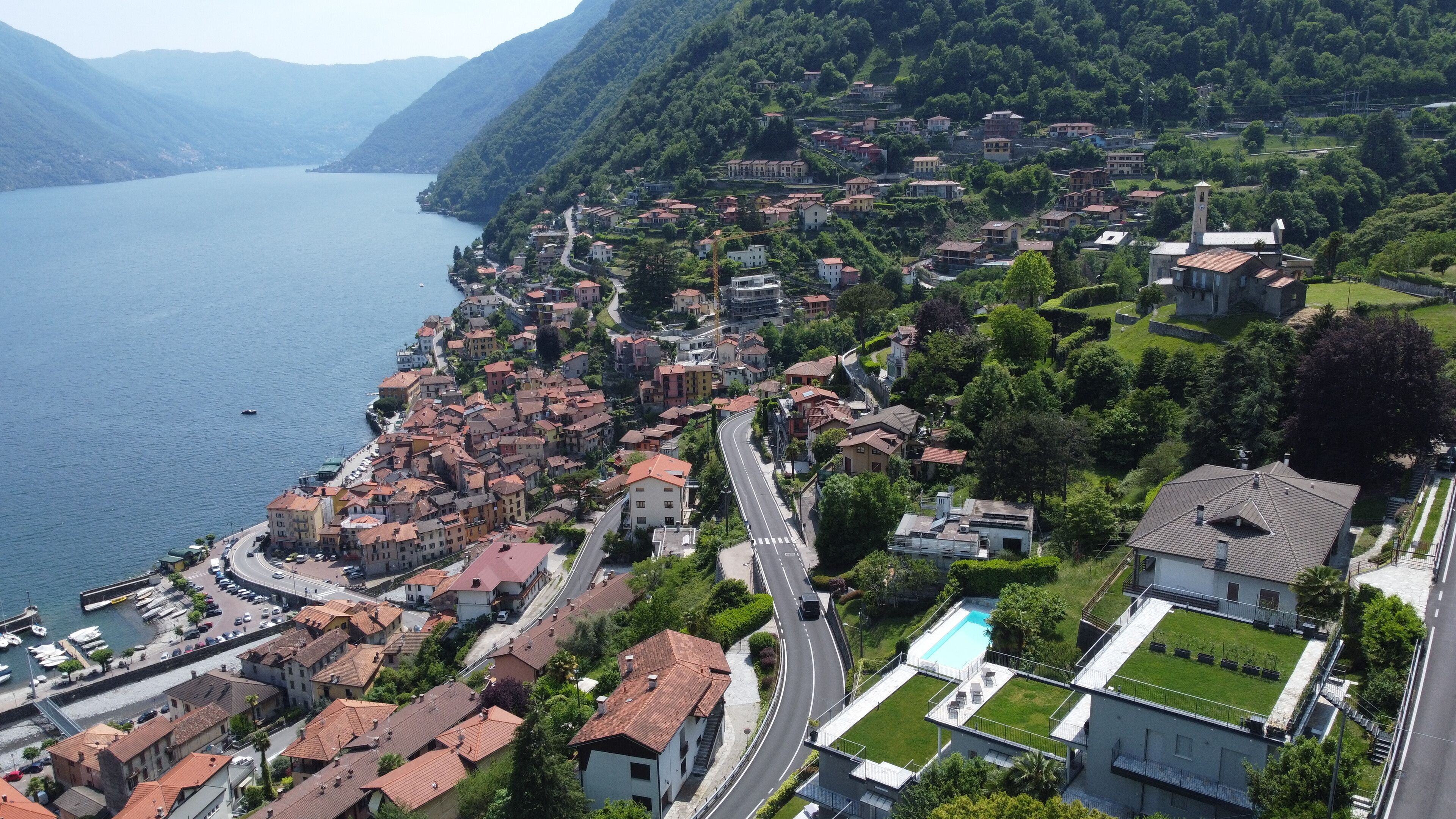 A coastal town with a marina, a winding road, and a mix of residential and commercial buildings.