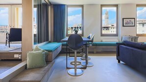 Una sala de estar moderna con comedor, ventanas grandes y vistas a una torre.