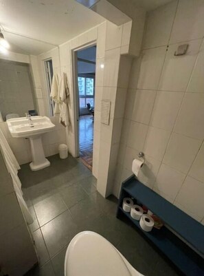 Bathroom features a pedestal sink, toilet, and towel rack.