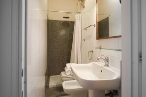 Ein Badezimmer mit Dusche, Toilette und Waschbecken.