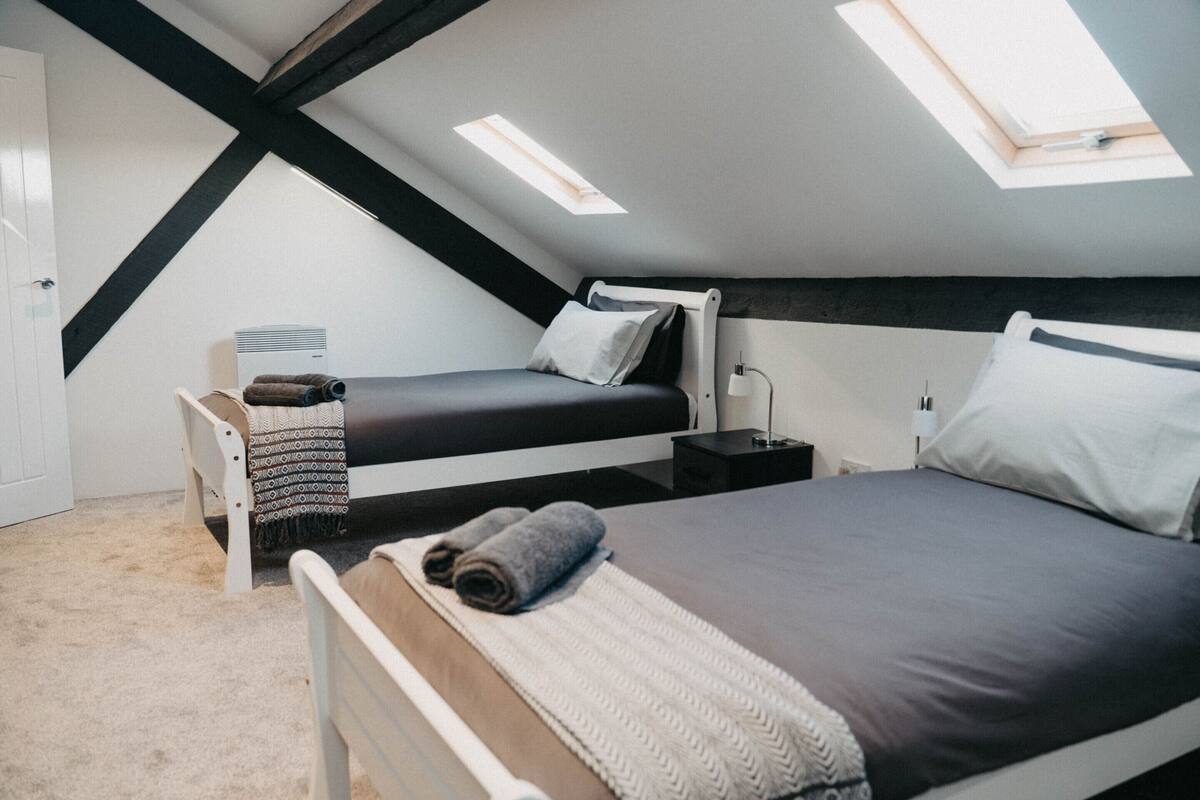 Ein Schlafzimmer mit zwei Betten, einem Oberlicht und einer weißen Tür.
