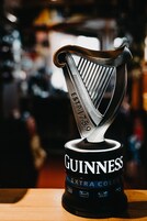 A Guinness Extra Cold beer can with a harp design.