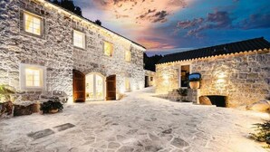 A stone building with arched doorways and a courtyard. - Villa Mediterranean Estate (Uskoplje)