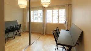 A room with a wooden herringbone floor, a glass partition, a table with chairs, and a large window with curtains. - Amplio y Silencioso en Recoleta Luz (Buenos Aires)