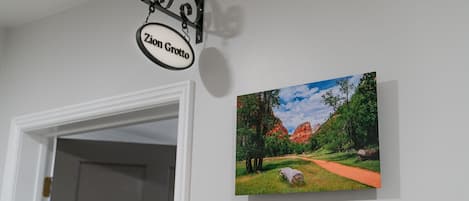 A sign reading "Zion Grotto" and a landscape painting on a wall.