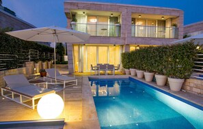 A modern two-story house with a swimming pool, outdoor seating, and potted plants. - Stunning home in Petrcane (Petrcane)