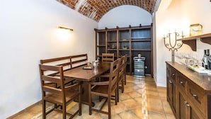 A dining area with a brick ceiling, wooden furniture, and a tiled floor.