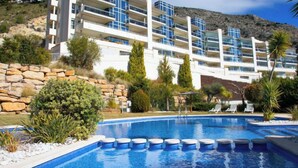 Ein modernes Hotel mit Poolbereich, eingebettet in eine natürliche Landschaft und felsiges Gelände.