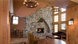 A cozy room with a stone fireplace, wooden furniture, and large windows. - R&R for 6 | Prime Location + Exclusive Privacy! (Keystone)
