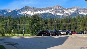 A parking lot with cars and a mountain backdrop. - Hotel Style 1 Bedroom & Bathroom (Fernie)