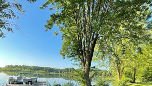 Ein Sitzbereich im Freien am Seeufer mit Adirondack-Stühlen und einem Feuerkorb.
