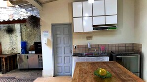 Una cocina con una mesa de madera, un fregadero y armarios.