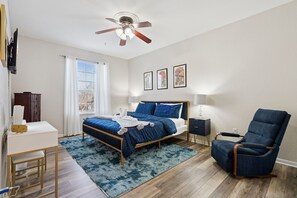 A bedroom with a bed, a desk, a chair, a ceiling fan, and framed artwork on the wall. - Bayou Bliss- Welcome Y'all! 3 bedroom condo super close to Walt Disney World! (Kissimmee)