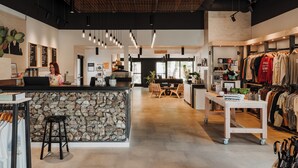 Una tienda moderna con mostrador de piedra, muebles de madera y percheros.