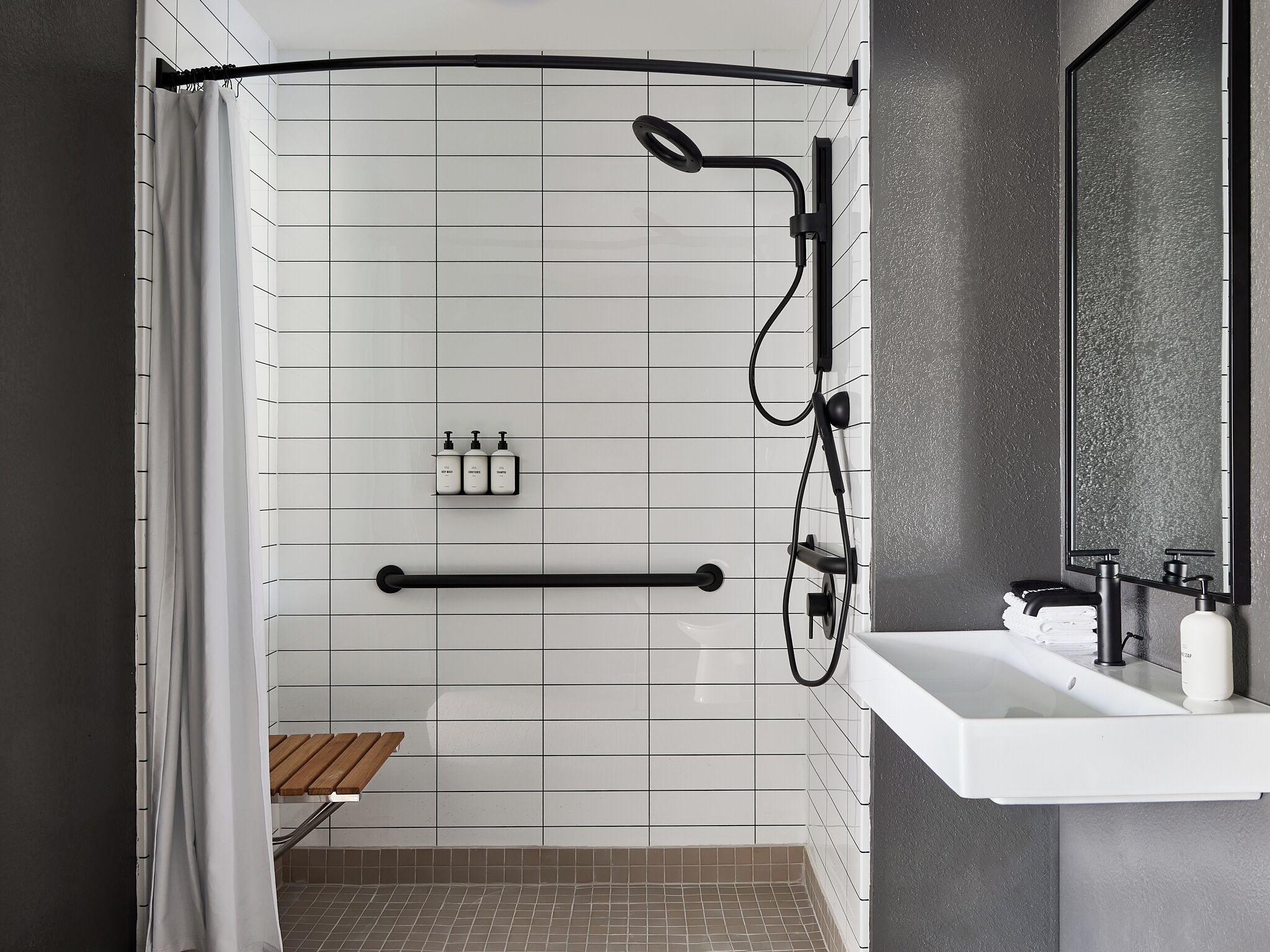 Un baño moderno con ducha, lavabo y espejo.