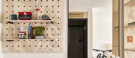 A bathroom with a wooden pegboard wall, a large mirror, and a white sink.