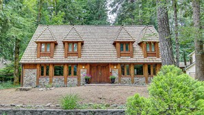 A log cabin with a stone foundation, wooden exterior, and a stone retaining wall. - Mt. Hood Alpine Chalet w/ hot tub, kid & dog friendly (Rhododendron)