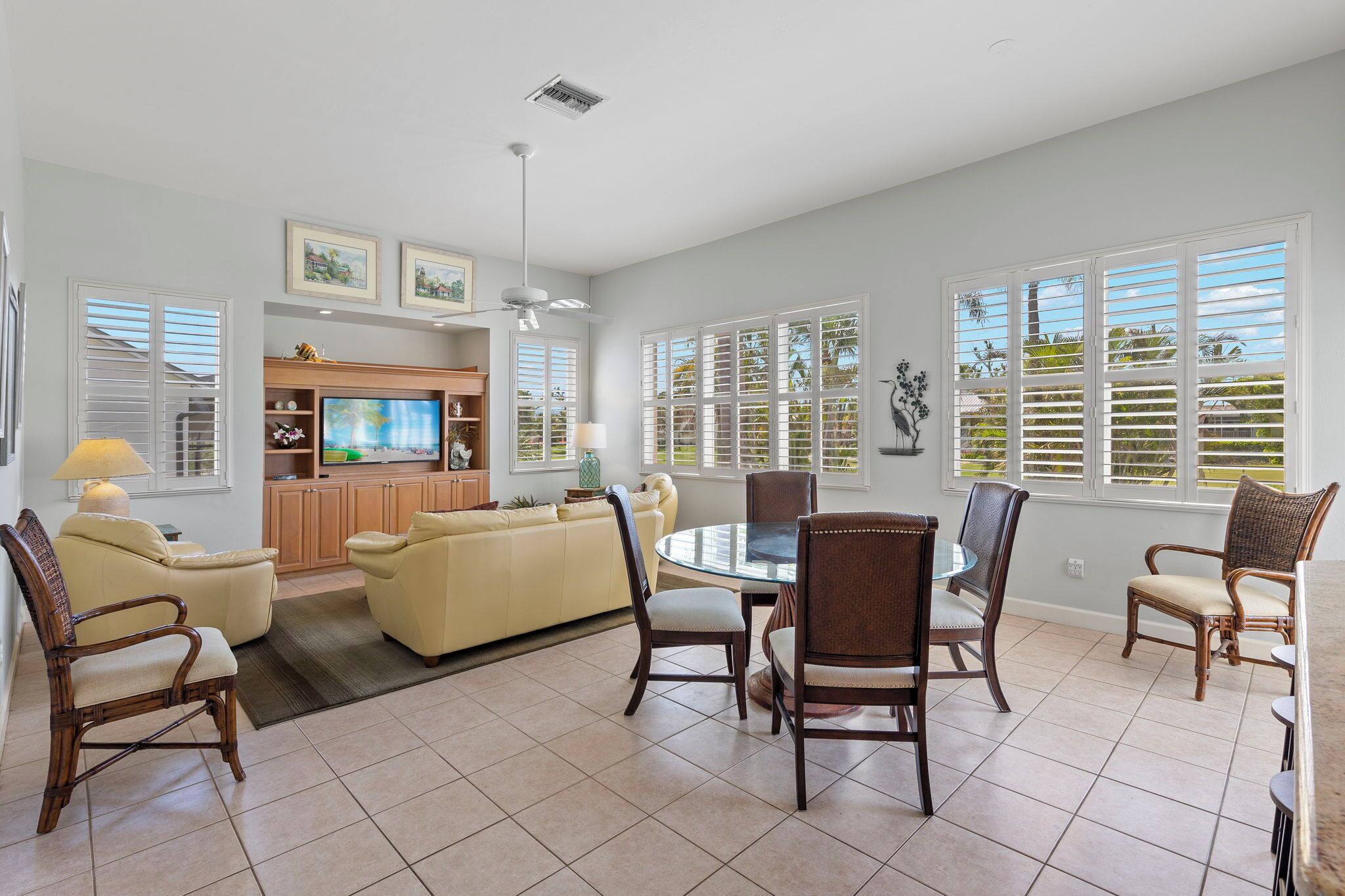 A spacious living area with a dining table, chairs, a sofa, and a television.