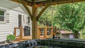 A hot tub with a wooden deck, a barbecue grill, and a small shed in a backyard. - Charming Mtn Cabin, Hot Tub+Fire Pit, Private, WiFi, Grill, Near Green Mtn Area! (Green Mountain)