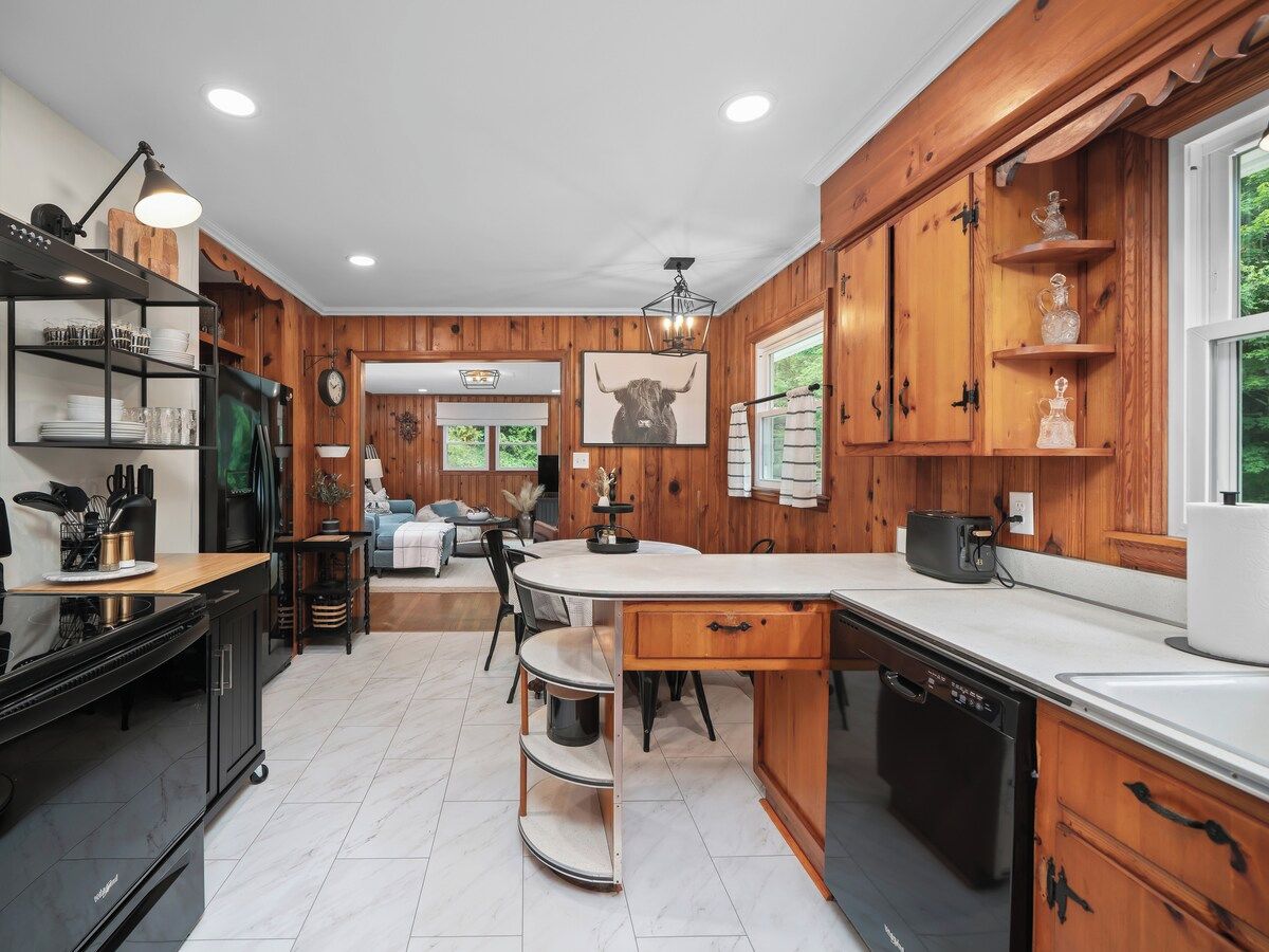 A kitchen with wooden cabinets, a central island, and a dining area.