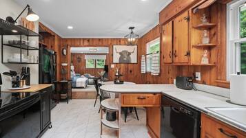 A kitchen with wooden cabinets, a central island, and a dining area.