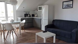 Een compacte woonruimte met een kitchenette, een eethoek en een zithoek.