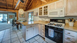 A kitchen with wooden cabinets, a stove, and a microwave. - Delton Oasis Retreat w/ Lake Views & Deck! (Delton)