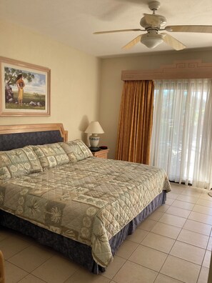 Relax in comfort with a large bed, bedside table, and framed artwork.