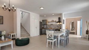 Eine moderne Küche mit Essbereich, einer Treppe und einem Wohnzimmer mit Sofa und Beistelltisch.