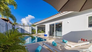 A modern house with a swimming pool, outdoor seating, and a covered patio. - *NEW* Modern 3BR2BA Home w/ Private Pool & Patio (Oranjestad)