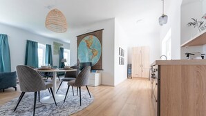 A modern kitchen with wooden cabinets, a countertop, and a hanging light fixture.