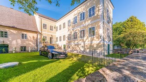 Un bâtiment à deux étages avec une allée pavée et une voiture garée.