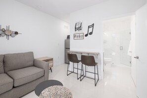 Relax in a stylish living space with a sofa, coffee table, and bar area, perfect for socializing.