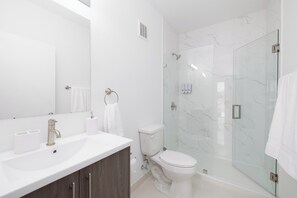 Enjoy a spa-like experience in this bathroom with a sink, glass-enclosed shower and toilet.