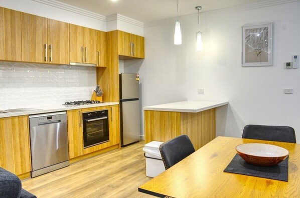 Enjoy cooking in this fully equipped kitchen with a dishwasher, oven, and refrigerator.