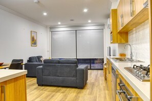 Cozy living space with a kitchenette, sofa, dining area, and closet.